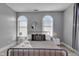 Charming bedroom features two arched windows, side tables, and an eye-catching mirror at 304 N College Ave # Apt B, Indianapolis, IN 46202