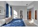 Bright bedroom with gray walls has large window with drapes and doorway to connected room at 304 N College Ave # Apt B, Indianapolis, IN 46202