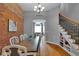 Open dining room with exposed brick wall, hardwood floors, access to living room and view of stair case at 304 N College Ave # Apt B, Indianapolis, IN 46202