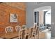 Bright dining room with exposed brick wall, hardwood floors, chandelier, and view to the living room at 304 N College Ave # Apt B, Indianapolis, IN 46202