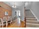 Open dining room with exposed brick wall, hardwood floors, and direct access to staircase and living room at 304 N College Ave # Apt B, Indianapolis, IN 46202