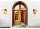Arched entryway with glass paneled doors, classic sconces, and a welcome mat for guests at 304 N College Ave # Apt B, Indianapolis, IN 46202