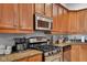Close up view of the kitchen featuring stainless steel appliances, granite countertops, and rich wood cabinetry at 304 N College Ave # Apt B, Indianapolis, IN 46202