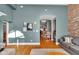 View from living room to dining room showcases open layout with exposed brick, wooden floors and gray walls at 304 N College Ave # Apt B, Indianapolis, IN 46202