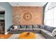 Open living room with exposed brick wall, hardwood floors, large gray couch and an arched window at 304 N College Ave # Apt B, Indianapolis, IN 46202