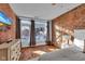 Bright bedroom with exposed brick wall, hardwood floors, dresser, and large windows for lots of natural light at 304 N College Ave # Apt B, Indianapolis, IN 46202