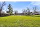 Brick ranch house with a large grassy backyard and mature trees at 3699 Lisa Ln, Plainfield, IN 46168