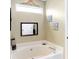 Bathroom with corner bathtub, decorative accents, and window at 5340 Thompson Park Blvd, Indianapolis, IN 46237
