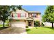 Charming two-story home with a well-maintained lawn, attached garage, and inviting front porch at 5340 Thompson Park Blvd, Indianapolis, IN 46237