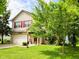 Inviting two-story home with a well-manicured lawn and mature trees at 5340 Thompson Park Blvd, Indianapolis, IN 46237