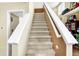 Beige carpeted staircase with white railings at 5340 Thompson Park Blvd, Indianapolis, IN 46237
