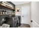 Laundry room with dark walls and modern appliances. Wood shelves and a modern painting on the wall at 5766 Aleppo Ln, Greenwood, IN 46143