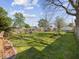 Spacious backyard featuring a lush lawn, a wooden fence, mature trees, and a playset at 619 Fair Ave, Shelbyville, IN 46176