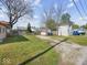 Large backyard with a gravel drive, wooden sheds, and mature trees, offering a versatile outdoor space at 619 Fair Ave, Shelbyville, IN 46176