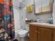 Functional bathroom featuring a shower-tub combo with floral curtain and a single sink vanity with storage at 619 Fair Ave, Shelbyville, IN 46176