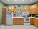 Charming kitchen features wooden cabinets, white appliances, and bright countertops, creating a cozy cooking space at 619 Fair Ave, Shelbyville, IN 46176