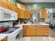 This cozy kitchen features wooden cabinets and appliances, including a microwave and stove, set against green walls at 619 Fair Ave, Shelbyville, IN 46176