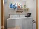 Bright laundry room featuring a stacked washer and dryer, with shelving for storage of laundry supplies at 619 Fair Ave, Shelbyville, IN 46176