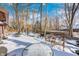 Snowy backyard with patio furniture and wooded area at 7425 Cherryhill Dr, Indianapolis, IN 46254