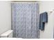 Simple bathroom with shower, toilet, and blue shower curtain at 7425 Cherryhill Dr, Indianapolis, IN 46254