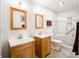 Beautiful bathroom featuring double sinks, wooden cabinetry, and a luxurious marble tiled shower with glass door at 7629 Farm View W Cir, Indianapolis, IN 46256