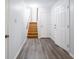 Bright hallway with staircase and wood-look vinyl flooring at 7629 Farm View W Cir, Indianapolis, IN 46256