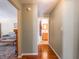 Hallway leading to bathroom with hardwood floors and light gray walls at 7629 Farm View W Cir, Indianapolis, IN 46256