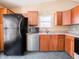 Kitchen featuring stainless steel dishwasher, black refrigerator, and tile flooring at 7629 Farm View W Cir, Indianapolis, IN 46256
