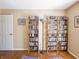 Bright living room area with hardwood floors, a door, and ample storage with built-in bookcases at 7629 Farm View W Cir, Indianapolis, IN 46256
