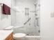 Modern bathroom shower with glass enclosure, marble-style tile, built-in shelves, and shower seat at 7629 Farm View W Cir, Indianapolis, IN 46256