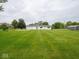 Expansive backyard with lush green lawn leading to a well-maintained house with white siding at 901 N 700 W, Greenfield, IN 46140