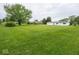 Large backyard with green lawn and trees, and well-maintained white house in the distance at 901 N 700 W, Greenfield, IN 46140