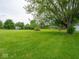 Expansive backyard with lush green grass and mature trees, offering ample space at 901 N 700 W, Greenfield, IN 46140