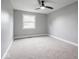 Bright bedroom featuring a ceiling fan, neutral carpeting, and a window with outdoor views at 901 N 700 W, Greenfield, IN 46140
