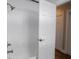 Tiled shower with glass door, paired with white door, and wood flooring in adjacent space at 901 N 700 W, Greenfield, IN 46140