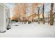 Snowy backyard with mature trees and landscaping at 1017 Village Cir, Greenwood, IN 46143