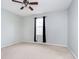 Simple bedroom with carpeted floor, ceiling fan, and window with curtains at 1421 E New York St, Indianapolis, IN 46201
