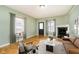 Light green living room with hardwood floors, fireplace, and staged furniture at 1421 E New York St, Indianapolis, IN 46201