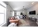 Living room with hardwood floors, leather couch, and view into dining area at 15428 Wandering Way, Noblesville, IN 46060