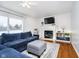 Living room with a fireplace, hardwood floors, and a blue sectional sofa at 18641 Wychwood Pl, Noblesville, IN 46062