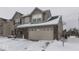 Two-story house with beige siding, brick accents, and a two-car garage in the snow at 2114 St Clifford Dr, Indianapolis, IN 46239