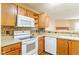 Kitchen boasts wood cabinets, white appliances, and a mosaic backsplash at 2716 Redland Ln, Indianapolis, IN 46217