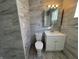 Clean bathroom featuring grey tile, white vanity, and toilet at 3305 E 30Th St, Indianapolis, IN 46218