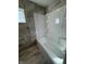 Updated bathroom with grey tile, a shower/tub combo, and shelving at 3305 E 30Th St, Indianapolis, IN 46218