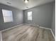 Spacious bedroom with grey walls, wood-look floors, and two windows at 3305 E 30Th St, Indianapolis, IN 46218