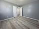 Simple bedroom with grey walls, wood-look floors, and access to other rooms at 3305 E 30Th St, Indianapolis, IN 46218