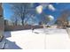 A snow-covered backyard with a wooden fence, some bare trees, and neighboring houses at 4014 N Capitol Ave, Indianapolis, IN 46208