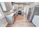 Bright kitchen with stainless steel appliances, granite countertops, and woodgrain flooring at 4014 N Capitol Ave, Indianapolis, IN 46208