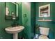 Powder room with a pedestal sink and dark green walls at 4049 Forbes Rd, Bargersville, IN 46106