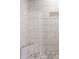 Modern shower with marble-look tile, built-in seat, and pebble floor at 502 Lockerbie S Cir, Indianapolis, IN 46202